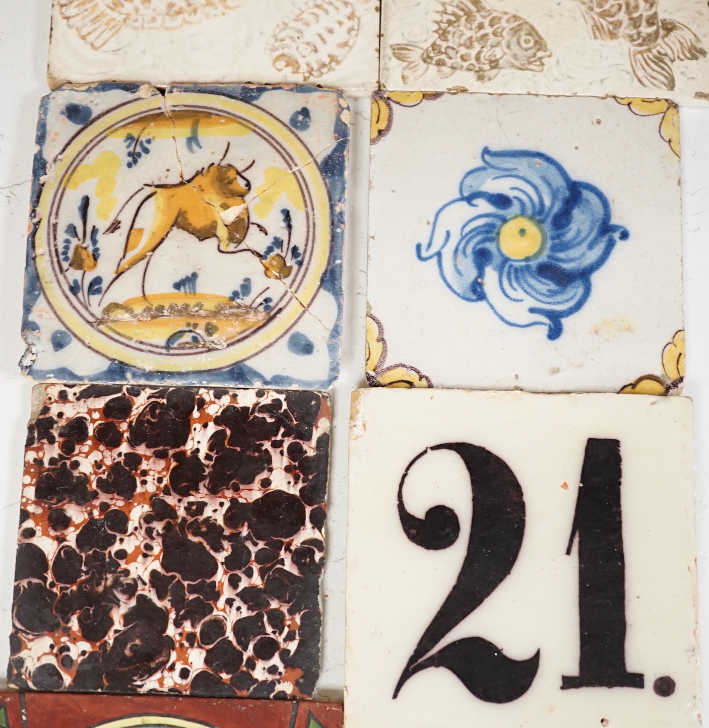 A collection of Continental tiles including 17th & 18th century Delft, Pre-Raphaelite style and two lustre fish examples, largest 15 x 15cm (9)